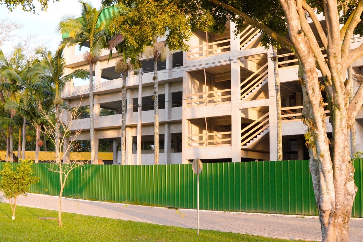 Obra comercial em andamento em Criciúma, com fachada de loja sendo finalizada por equipe de construção