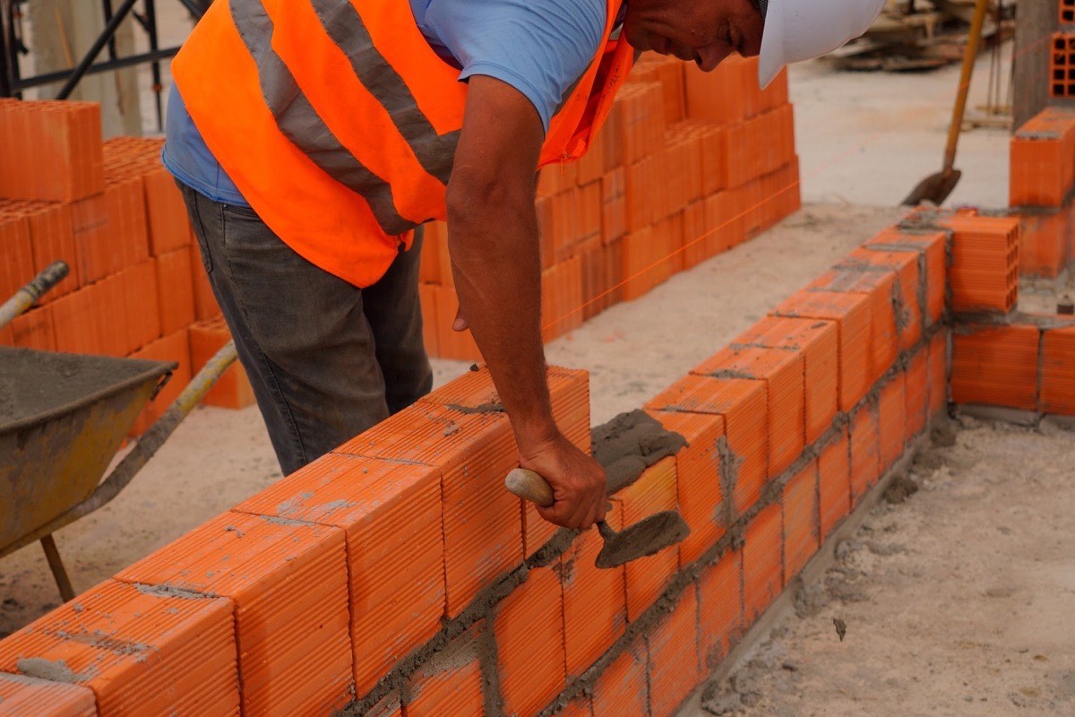 Fachada de prédio comercial de salas em construção em Criciúma, com estrutura de concreto aparente e vagas de estacionamento sendo demarcadas
